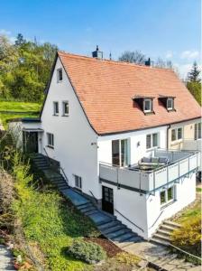 un grand bâtiment blanc avec un toit rouge dans l'établissement Spacious house for large groups and families, à Wurtzbourg
