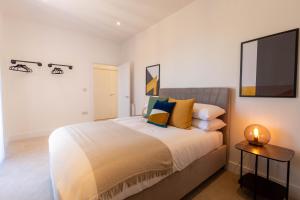 a bedroom with a bed and a tv on the wall at Modern Apartments with Balcony in Merton near Wimbledon by Sojo Stay in Mitcham