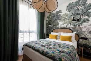 um quarto com uma cama grande e almofadas amarelas em Avalon Cosy Hotel Paris em Paris