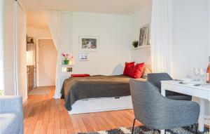a bedroom with a bed with red pillows and a desk at Amazing Apartment In Helsingr With Kitchen in Helsingør