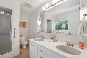 a bathroom with two sinks and a toilet and a mirror at Viewcrest Retro Country Home in Orick +32 photos