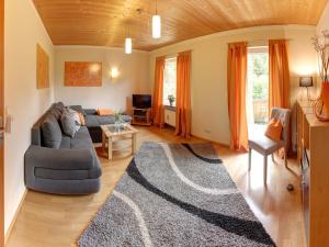 sala de estar con sofá y alfombra en Ferienwohnung Hartwimmer - Chiemgau Karte, en Inzell