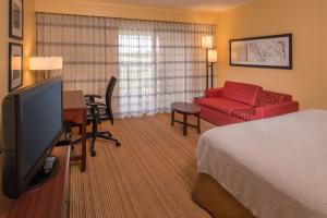 une chambre d'hôtel avec un lit et un salon dans l'établissement Courtyard by Marriott North Charleston Airport Coliseum, à Charleston