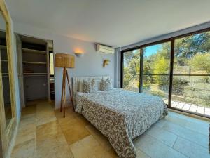 um quarto com uma cama e janelas grandes em "Grand Bleu" Villa direkt am Meer em La Seyne-sur-Mer