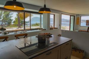 uma cozinha com janelas e um balcão com uma mesa em "Grand Bleu" Villa direkt am Meer em La Seyne-sur-Mer