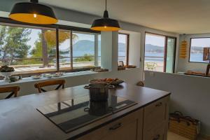 a kitchen with windows and a counter with a table at "Grand Bleu" Villa direkt am Meer in La Seyne-sur-Mer
