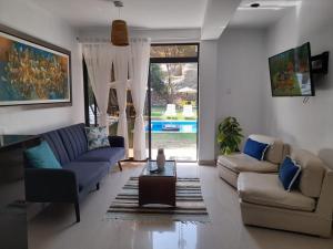萬查科的住宿－Montemar Apart Hotel - Playa Huanchaco，客厅配有两张沙发和一张桌子