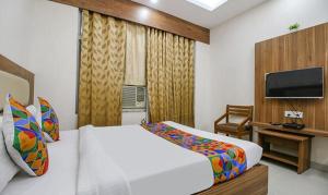 a bedroom with a bed and a flat screen tv at FabHotel Silver Inn I in Bhopal