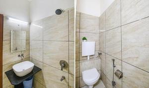 ein Bad mit einem WC, einem Waschbecken und einer Dusche in der Unterkunft FabHotel Silver Inn I in Bhopal