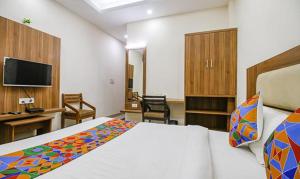 a bedroom with a bed and a desk and a tv at FabHotel Silver Inn I in Bhopal