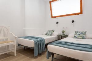 een kamer met 2 bedden en een raam bij Apartamento Piolín in L'Escala