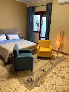 a bedroom with a bed and a pair of chairs and a couch at Saphir b&b in Nardò