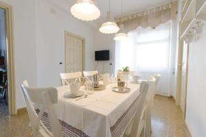 een witte eetkamer met een witte tafel en stoelen bij Portuense1499 in Ponte Galeria
