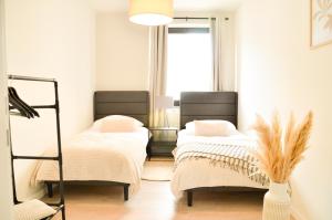 a room with two beds and a window at MILPAU Bottrop 2 - Modernes und zentrales Premium-Apartment für 4 Personen mit Queensize-Bett und Einzelbetten - Netflix, Nespresso und Smart-TV in Bottrop