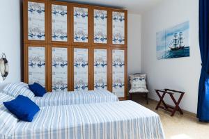 twee bedden in een kamer met blauwe en witte lakens bij Portuense1499 in Ponte Galeria