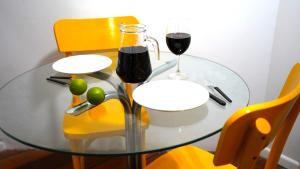 阿雷格里港的住宿－Cabana de Gramado em POA，一张玻璃桌,上面放着两杯葡萄酒