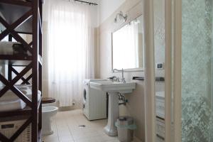 een badkamer met een wastafel, een toilet en een spiegel bij Portuense1499 in Ponte Galeria +39 foto's