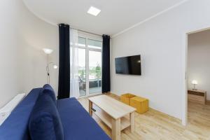 sala de estar con sofá azul y TV en Apartament Słoneczny Ku Morzu by HolidaySun, en Sianożęty