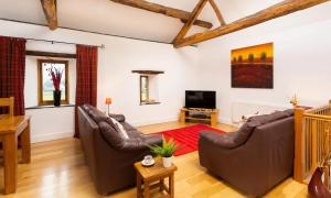uma sala de estar com dois sofás e uma televisão em The Mistal em Newby Bridge