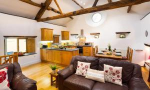 a living room with a couch and a kitchen at The Mistal in Newby Bridge