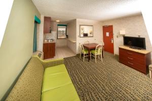 a hotel room with a bed and a living room at The Breakers Resort Inn in Virginia Beach