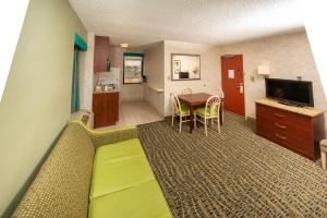 une chambre d'hôtel avec un lit et un salon dans l'établissement The Breakers Resort Inn, à Virginia Beach