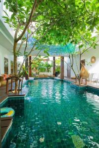 een groot zwembad met bomen in een gebouw bij Unparalleled pool villa in Bangkok