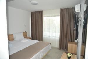a bedroom with a bed and a large window at Hotel Ancora in Eforie Sud