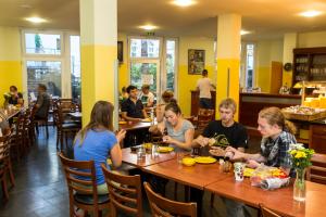 un groupe de personnes assises à table dans un restaurant dans l'établissement Pegasus Hostel Berlin, à Berlin