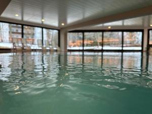 a pool of water in a room with windows at Appartementhaus Birkenwald in Seefeld in Tirol