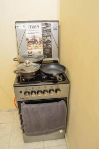 a stove with two pots and pans on top of it at One bedroom apartment-Bamburi Fisheries0711519879 in Mombasa
