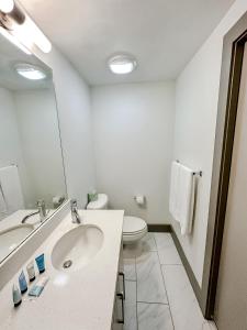 biała łazienka z umywalką i toaletą w obiekcie Sleepover High-end Downtown Springfield Apartments w mieście Springfield