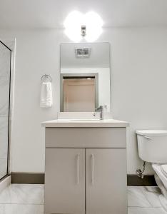 Baño blanco con lavabo y aseo en Sleepover High-end Downtown Springfield Apartments en Springfield