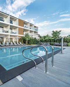 a swimming pool with chairs next to a building at Rosa Style in Rowy