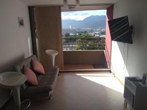 a living room with a couch and a large window at Mayorca cómodo y central in Sabaneta