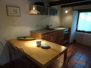 cocina con mesa de madera con sillas y fregadero en Casa Sonnenberg, en Bosco-Gurin
