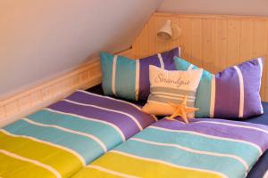 a bedroom with two beds with striped pillows at Huus Strandgut 9140 - Fehmarn in Avendorf auf Fehmarn