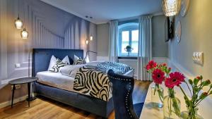 ein Schlafzimmer mit einem Zebra-Bett und einem Tisch mit Blumen in der Unterkunft Boutique Hotel POST ANDECHS in Andechs