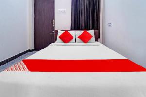 a bed with red pillows in a room at Hotel O Royal Residency in Nāmakkal +21 photos
