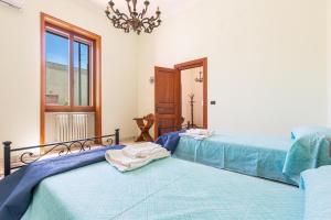 a bedroom with two beds and a chandelier at Casa di Paolo by BarbarHouse in Campi Salentina