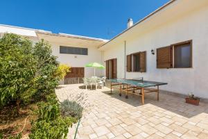 a patio with a ping pong table in front of a house at Casa di Paolo by BarbarHouse in Campi Salentina