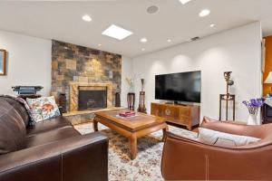 a living room with leather furniture and a fireplace at Escondido Villa w Movie Theater Garden GameRoom in Escondido
