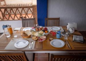 une table en bois avec des assiettes et des bols de fruits dans l'établissement B&B La Granadilla, à Cónchar