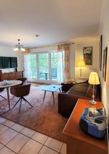 ein Wohnzimmer mit einem Sofa und einem Tisch in der Unterkunft Ferienwohnung Juliane in der Villa zum Kronprinzen direkt gegenüber der Saarow Therme in Bad Saarow