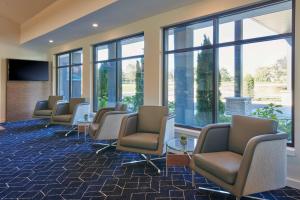 a waiting room with a row of chairs and windows at Courtyard Chicago Lincolnshire in Lincolnshire