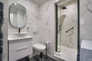uma casa de banho com um WC, um lavatório e um espelho. em Magnifique appartement proche Tour Eiffel em Paris