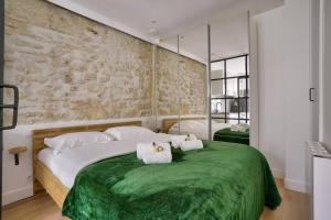 um quarto com uma cama grande e um cobertor verde em Magnifique appartement proche Tour Eiffel em Paris