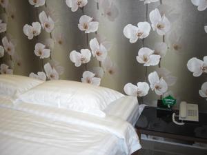 a bedroom with white flowers on the wall at Marvelot Hotel in Kajang