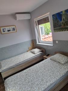 ein kleines Schlafzimmer mit 2 Betten und einem Fenster in der Unterkunft Hostel Kandulski in Posen