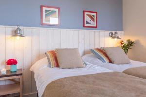 a bedroom with two beds and a blue wall at Appartement de Tamaris (4 pers) in Le Pouliguen